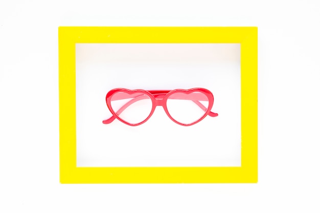 Free photo heart-shaped glasses inside frame