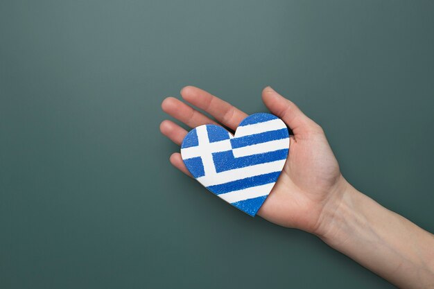 Heart shaped greece flag held in hands