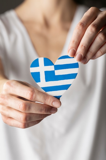 Heart shaped greece flag held in hands