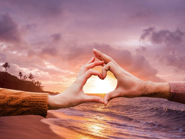 Heart-shaped hands on a sunset