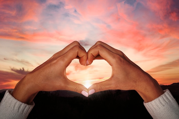 Free photo heart-shaped hands on a sunset