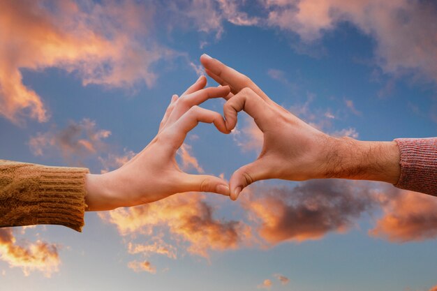 Heart-shaped hands on a sunset