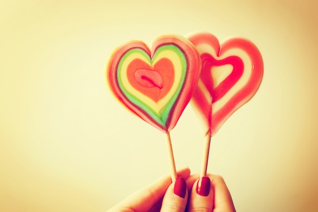 Heart-shaped lollipop held by a hand