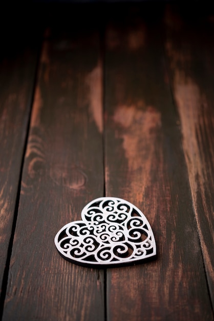Ornamento a forma di cuore su fondo di legno