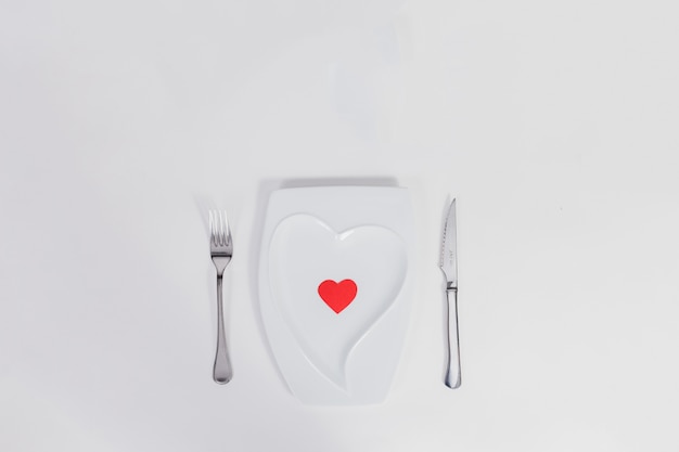 Free photo heart-shaped plate with cutlery