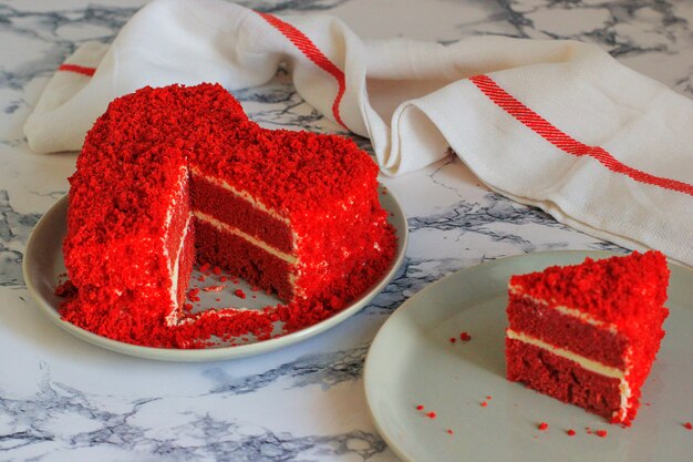 심장 모양의 대리석 테이블 조각 옆에 빨간 벨벳 케이크