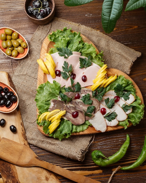 Foto gratuita piatto di legno a forma di cuore di lingua di manzo, al di fuori del deli tacchino