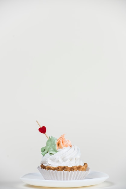 Free photo heart topper in cupcake on white table