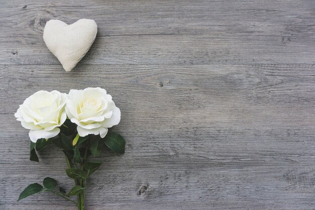 Heart and white flowers on wooden background