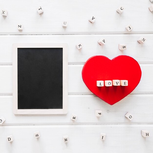 Free photo heart with love writing near blackboard