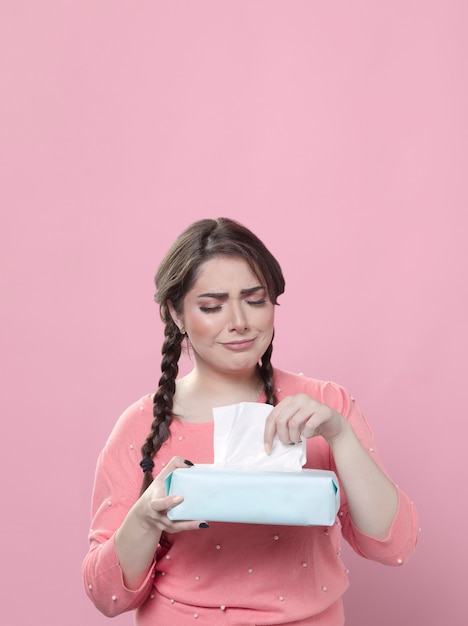 Heartbroken woman using box of napkins