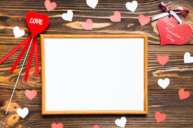 Free photo hearts around frame on wooden background