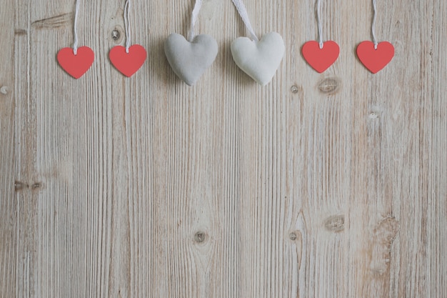 Hearts hanging from ropes on a wooden surface