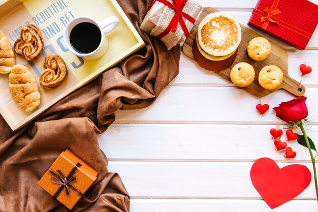 Hearts and rose near presents and breakfast