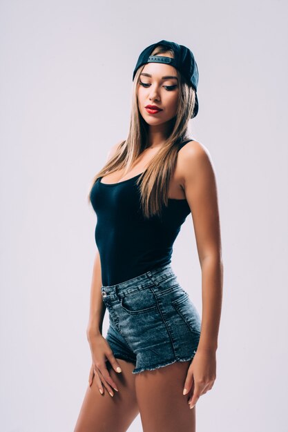 ショートパンツとキャップの若い女性のヘザーグレーの長袖Tシャツ、分離、コピースペース、モックアップ。