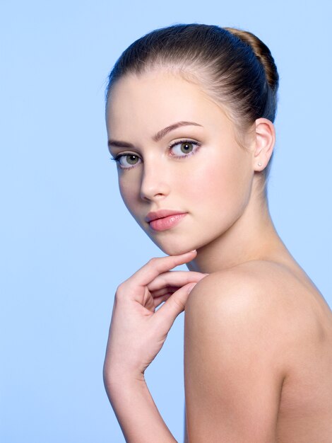 Heathy clean skin of young beautiful woman on blue