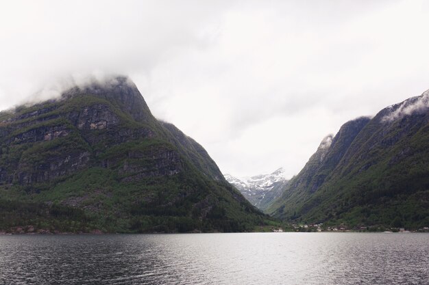 Heavy clouds hang over the lake among the mountains in Norway 