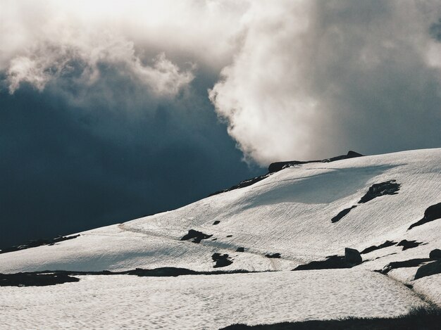 무거운 구름이 눈으로 덮여 산 위에 매달려