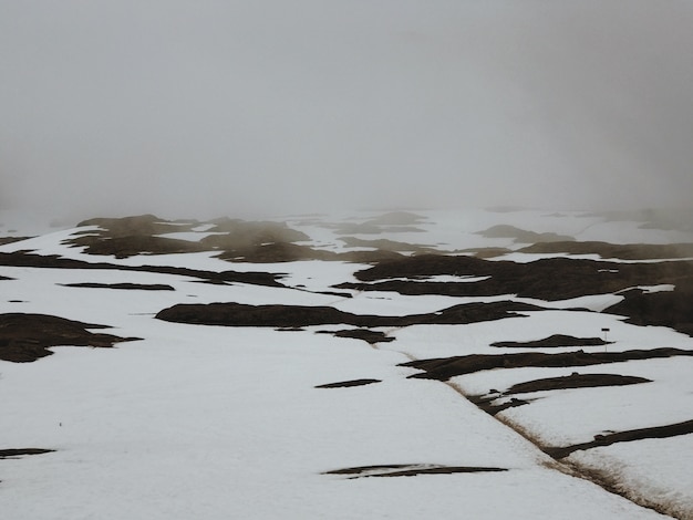 Heavy clouds hang over the mountains covered with snow