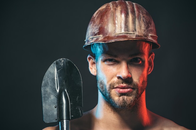 Тяжелая промышленность и рабочая концепция сексуальный строитель-ремонтник в защитном шлеме с лопатой