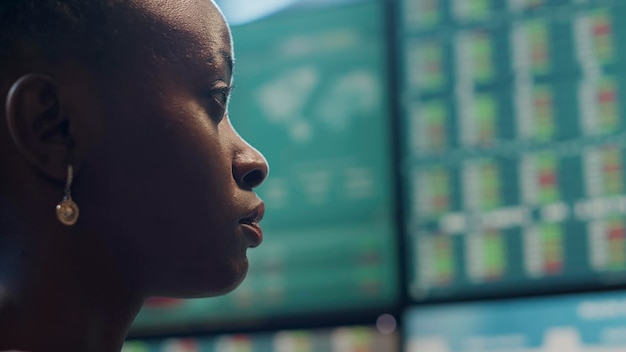 Hedge fund trader analyzing real time stocks on monitors, looking at financial exchange statistics in office. Forex trade market to obtain profit and price numbers. Close up. Handheld shot.