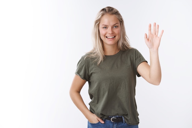 Hello nice to meet you. Portrait of friendly-looking charming outgoing female coworker with blond hair raise palm and wave in greeting smiling pleasant, welcoming guests to seminar saying hi