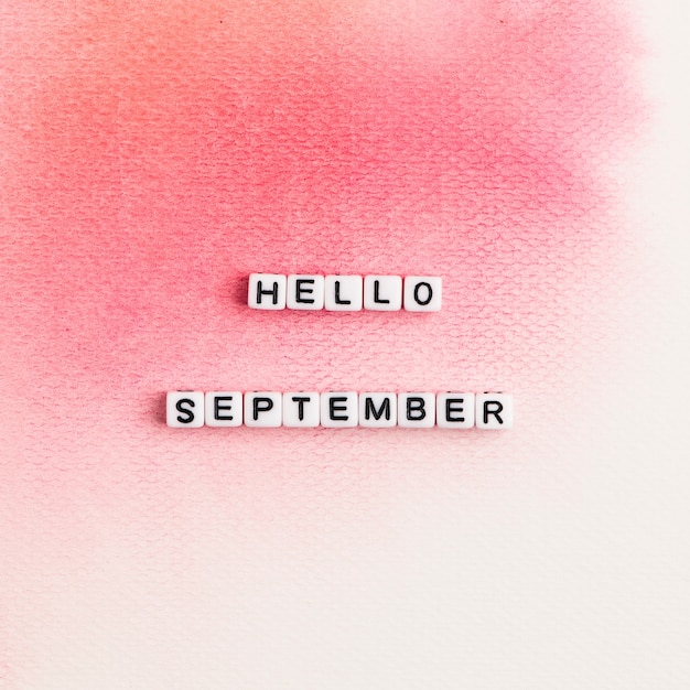 Free photo hello september beads message typography on pink