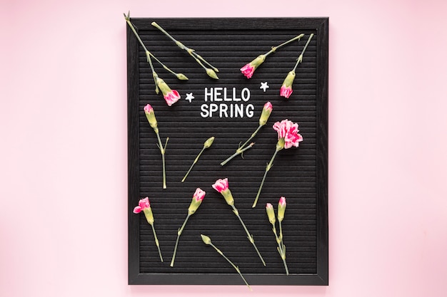 Hello Spring inscription with flowers on black board 