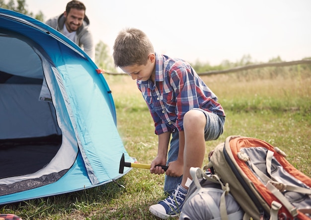 Foto gratuita utile figlio in campeggio con suo padre