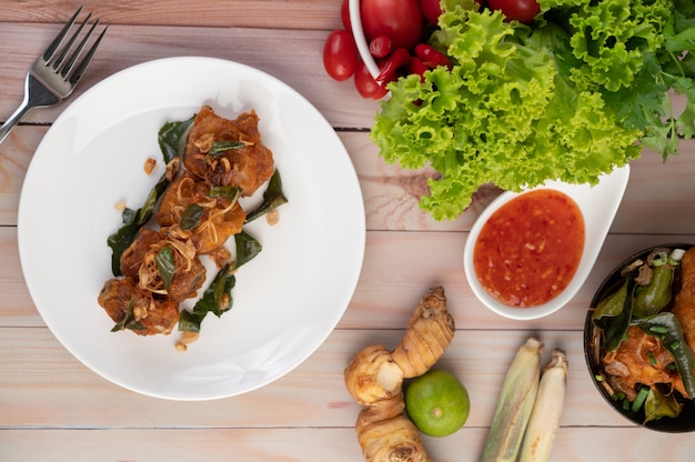 Herb fried chicken on a white plate on a wooden floor.