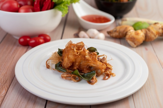 Herb fried chicken on a white plate on a wooden floor.