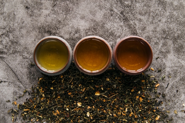 Herbal chinese teacup with dried tea herb on concrete backdrop