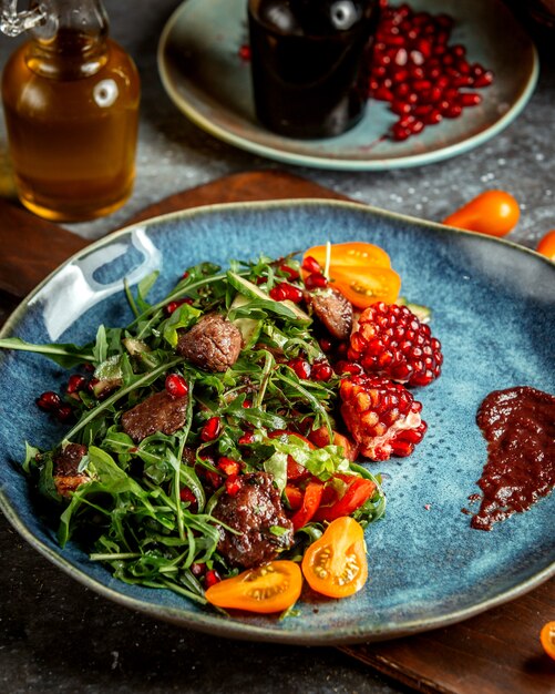 Herbal salad with meat and pomegranates