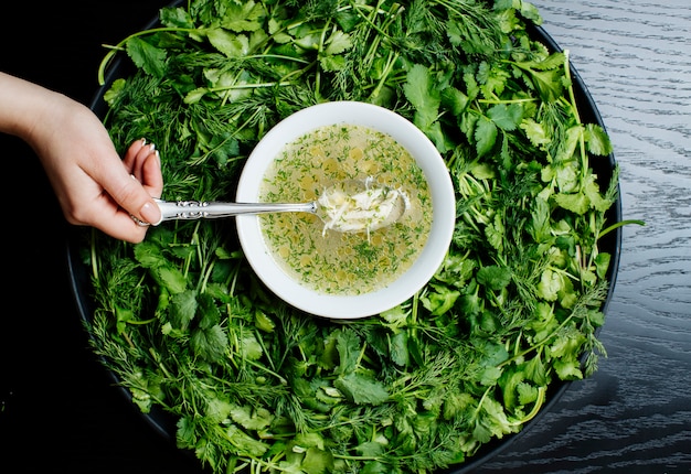 Herbal soup and with herbs on salver