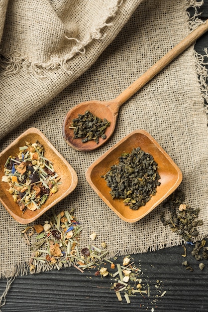 Herbal spices on wooden bowl and spoon over sack