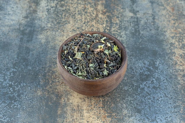 Herbal tea leaves in wooden bowl.