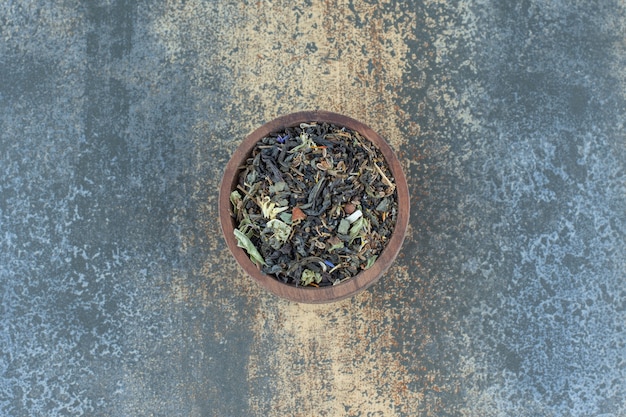 Herbal tea leaves in wooden bowl.