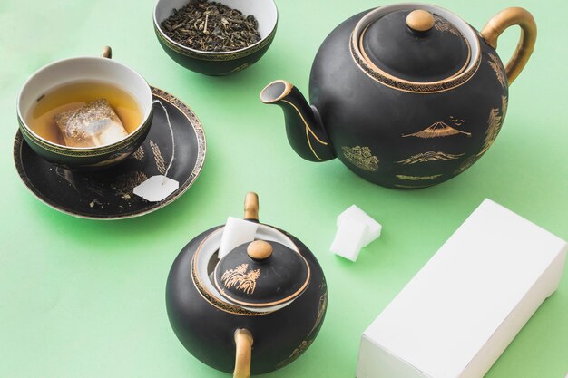 Herbal tea set with white box on green paper background