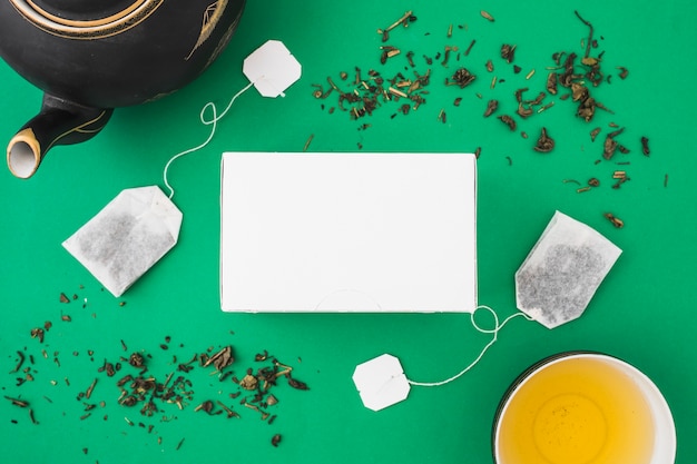 Herbal tea and teabag on green background