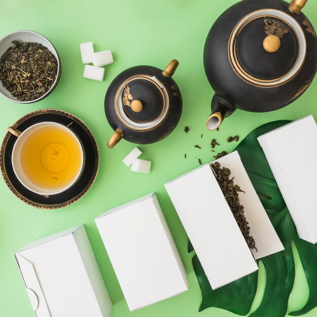 緑茶の背景にチョコレートと砂糖のキューブが付いているハーブホワイトボックス