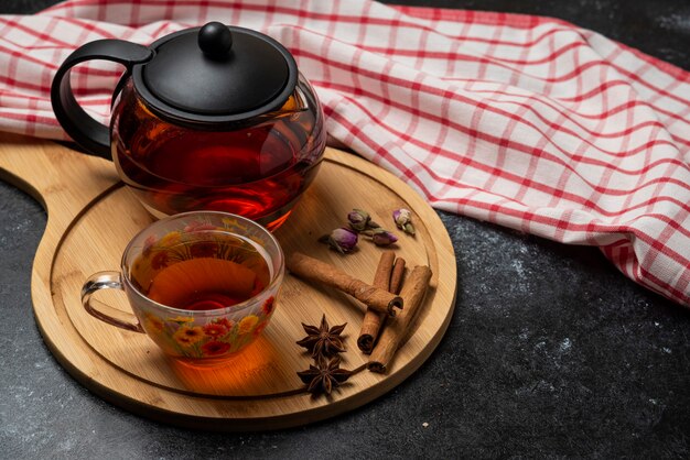 Herbal winter tea in the cups with spices on a wooden board. 