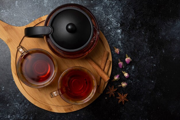 木の板にスパイスが入ったカップに入ったハーブの冬のお茶。