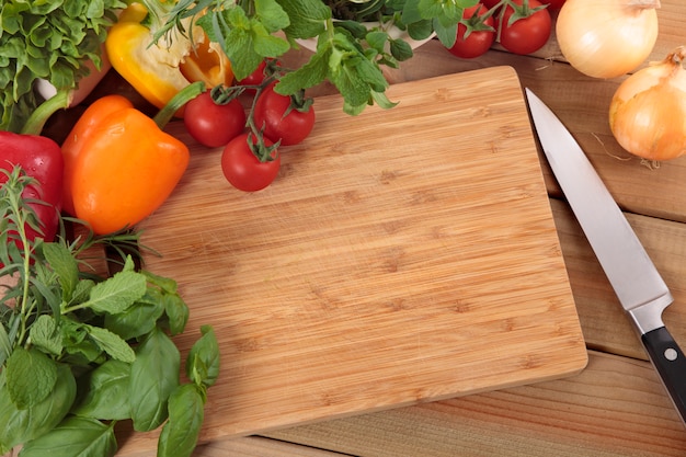 Herbs and vegetables with a chopping board