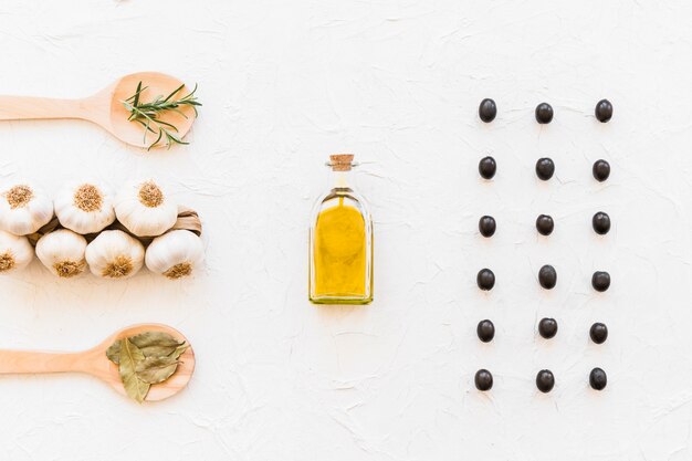 Free photo herbs with bunch of garlic bulb and oil bottle