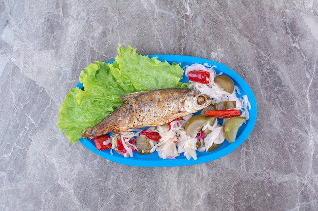 Free photo herring and pickled vegetables on blue plate.