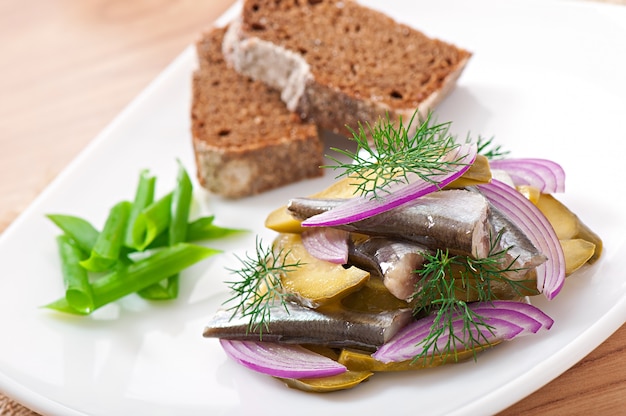 Free photo herring salad with pickled cucumbers and onions