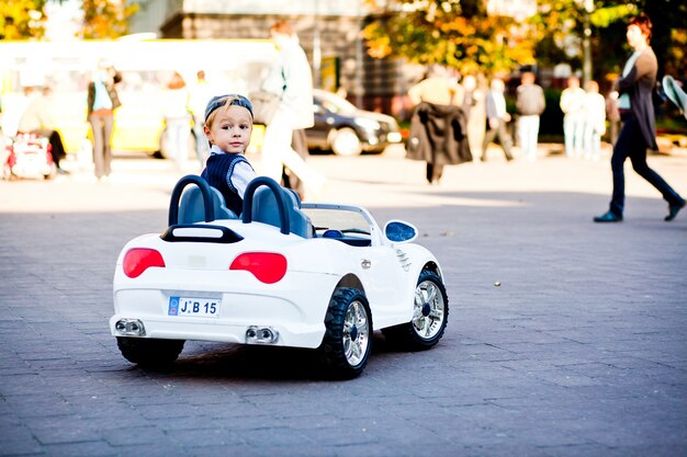 Hey, what is there? Cute little boy drives his first car