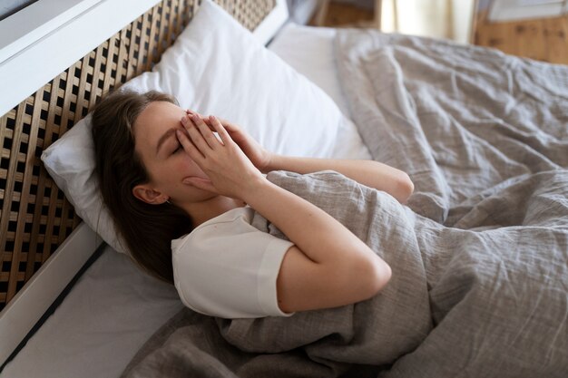 High angle anxious woman laying in bed