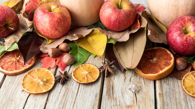 High angle of apple with dried citrus and autumn leaves