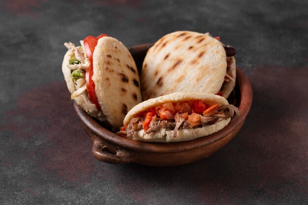 High angle arepas with meat and tomatoes